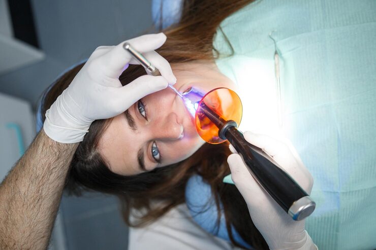 Dentist performing laser gum therapy